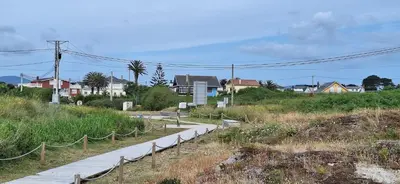 a path in the middle of a field with houses at Casa Diego, primera línea de playa junto a las Catedrales in Barreiros