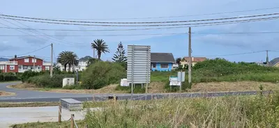 a sign on the side of a road with houses at Casa Diego, primera línea de playa junto a las Catedrales in Barreiros
