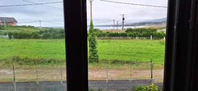 a view of a field from a window at Casa Diego, primera línea de playa junto a las Catedrales in Barreiros
