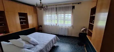 a bedroom with a bed with pillows and a window at Casa Diego, primera línea de playa junto a las Catedrales in Barreiros