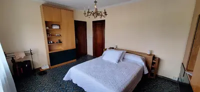 a bedroom with a bed and a chandelier at Casa Diego, primera línea de playa junto a las Catedrales in Barreiros