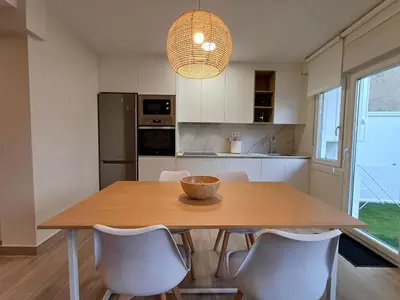a kitchen with a wooden table and white chairs at SF - Luminoso, amplio y recién reformado en el casco histórico in Ourense