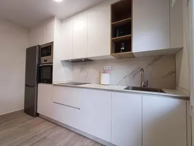 a kitchen with white cabinets and a stainless steel refrigerator at SF - Luminoso, amplio y recién reformado en el casco histórico in Ourense