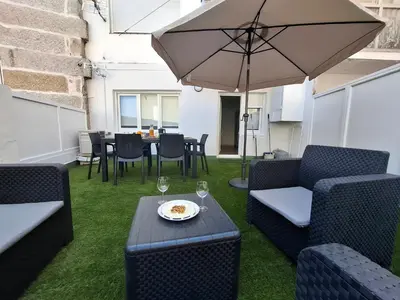 a patio with a table and chairs and an umbrella at SF - Luminoso, amplio y recién reformado en el casco histórico in Ourense