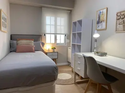 a bedroom with a bed and a desk and a desk at Apartamento Pardiñas in Santiago de Compostela