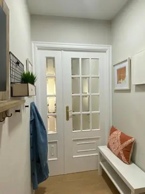 a white door in a room with a bench at Apartamento Pardiñas in Santiago de Compostela