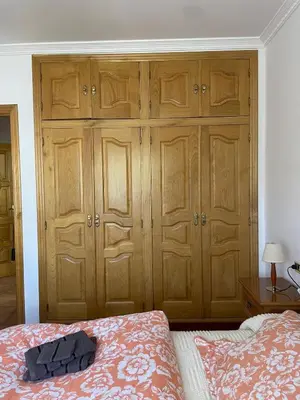 a bedroom with wooden cabinets and a bed at Acogedor piso en Sarria in Sarria