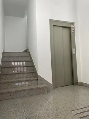 a hallway with stairs and a door in a building at Acogedor piso en Sarria in Sarria