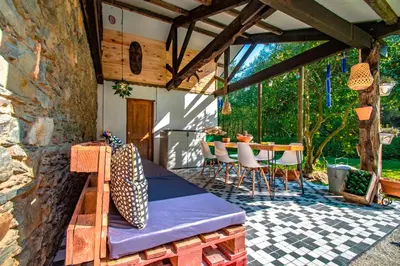 a patio with a bed and a table and chairs at Casa rural en Playa de Frejulfe in Frejulfe