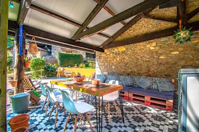 a patio with a table and chairs and a stone wall at Casa rural en Playa de Frejulfe in Frejulfe