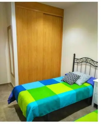 a bedroom with a colorful bed with a wooden door at Gatonegro in Trefacio