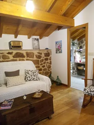 a living room with a couch and a stone wall at A Florentina in Rubiacós