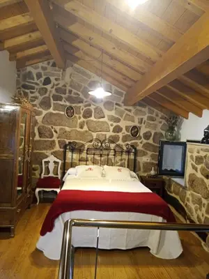 a bedroom with a bed in a stone wall at A Florentina in Rubiacós