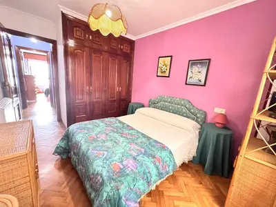 a bedroom with a bed and a pink wall at Apartamento Parquemar Viveiro in Viveiro