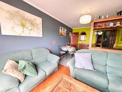 a living room with a blue couch and a table at Apartamento Parquemar Viveiro in Viveiro