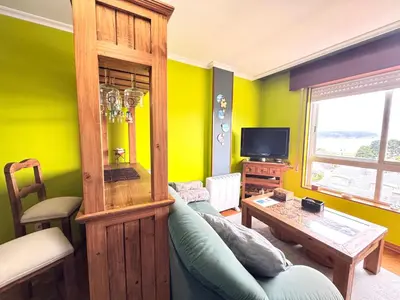 a living room with a blue couch and a table at Apartamento Parquemar Viveiro in Viveiro