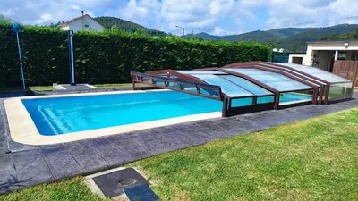 a large swimming pool with a bed in a yard at Casa de Invitados con asador y piscina de uso privado in Foz