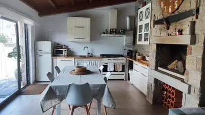 a kitchen with a table and chairs and a fireplace at Casa de Invitados con asador y piscina de uso privado in Foz