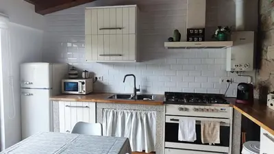 a kitchen with a refrigerator and a stove top oven at Casa de Invitados con asador y piscina de uso privado in Foz
