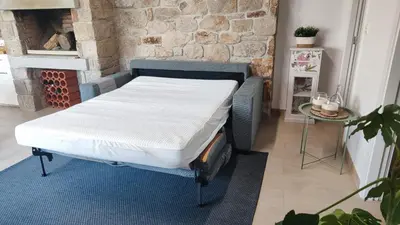 a bed in a room next to a brick wall at Casa de Invitados con asador y piscina de uso privado in Foz