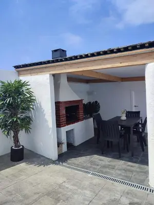 a patio with a table and a fireplace at O barco de Coto in Barreiros