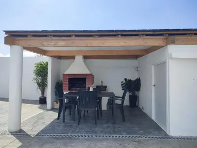 a table and chairs on a patio with a fireplace at O barco de Coto in Barreiros