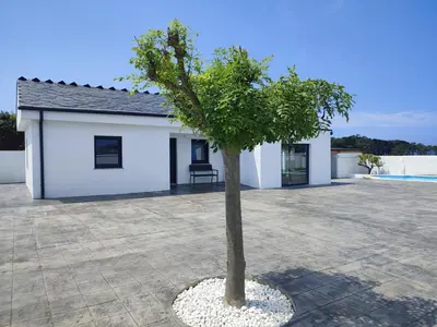 a tree in front of a white building at O barco de Coto in Barreiros
