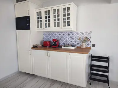 a kitchen with white cabinets and a wooden counter top at O barco de Coto in Barreiros