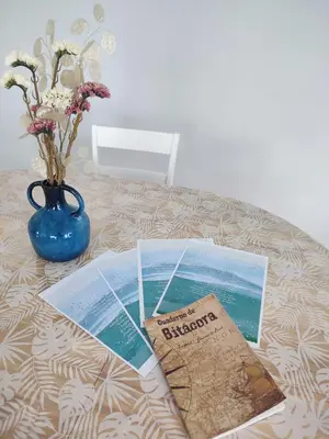 a table with a book and a vase of flowers at O barco de Coto in Barreiros