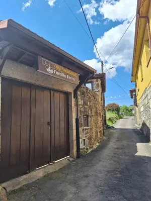a building with a wooden garage door on a street at Casa Vacacional Familia Ferro in Cartelle