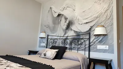 a bedroom with a bed with a painting on the wall at Casas rurales en Sanabria in Coso