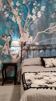 a bedroom with a bed and a wall with flowers at Casas rurales en Sanabria in Coso