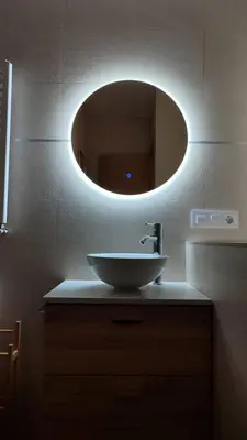 a bathroom with a sink and a round mirror at Casas rurales en Sanabria in Coso