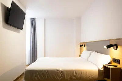 a hotel room with a bed and a flat screen tv at Pensión da Sela in Santiago de Compostela