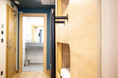 a bathroom with a wooden door and a sink at Pensión da Sela in Santiago de Compostela