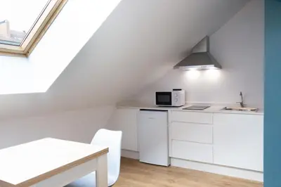 a kitchen with white cabinets and a microwave at Pensión da Sela in Santiago de Compostela