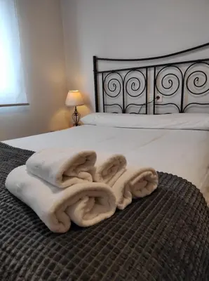 a bed with a pile of towels on it at Figueras 4 in figueras