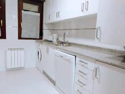 a white kitchen with white cabinets and a sink at Figueras 4 in figueras