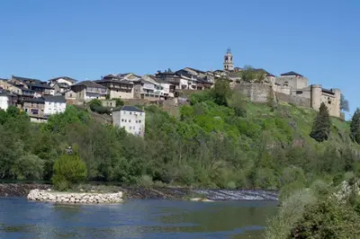 a group of buildings on a hill next to a river at Hotel Victoria in Puebla de Sanabria