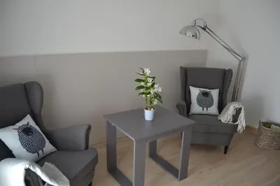 a living room with a table and two chairs and a lamp at Hotel Victoria in Puebla de Sanabria