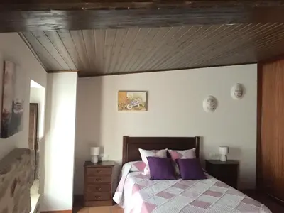 a bedroom with a bed with purple pillows at Casa Arteleira in Padrón