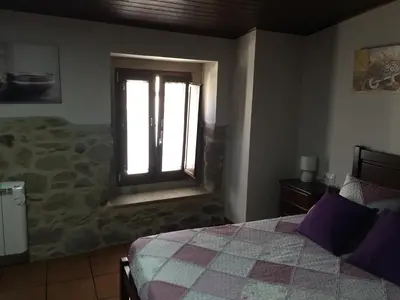 a bedroom with a bed and a window at Casa Arteleira in Padrón