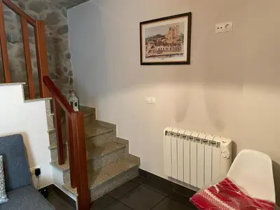 a staircase with a picture on the wall and a radiator at Casa Arteleira in Padrón