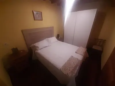 a small bedroom with a bed with white sheets and pillows at Casa valido in Lago