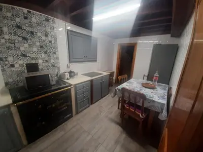 a kitchen with a table and a small kitchen with a table and a tableablish at Casa valido in Lago