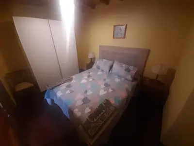 a bedroom with a bed with a blue and purple comforter at Casa valido in Lago