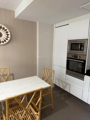 a kitchen with a table and a microwave oven at Apartamento centro de Foz con piscina in Foz