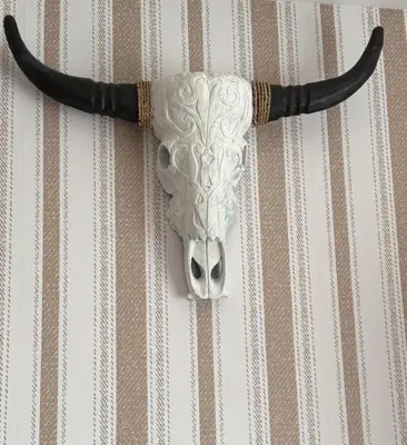 a mask of a bull with horns hanging on a wall at Apartamento centro de Foz con piscina in Foz