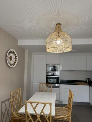 a kitchen with a table and chairs and a chandelier at Apartamento centro de Foz con piscina in Foz