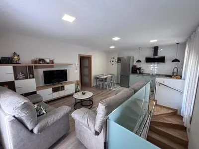 a living room with two couches and a kitchen at Casa Rural O Lar Das Fontiñas in Moreiras